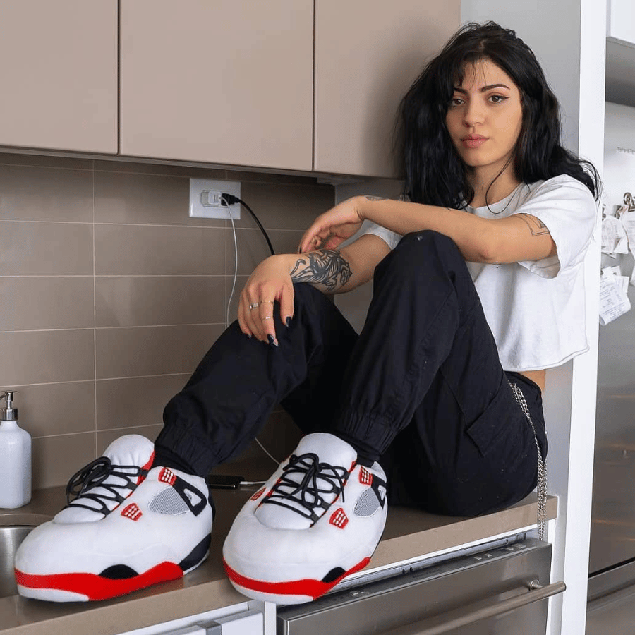 Une femme qui porte des chaussons sneakers assit sur sa cuisinière